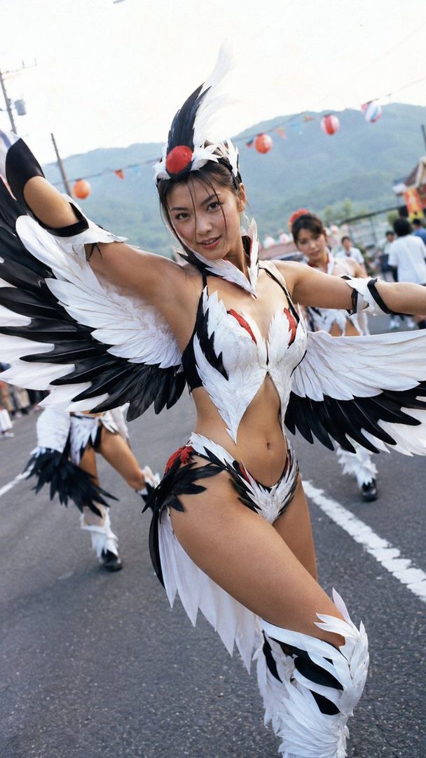 A woman in a black and white bird-themed costume with large wings poses outdoors.