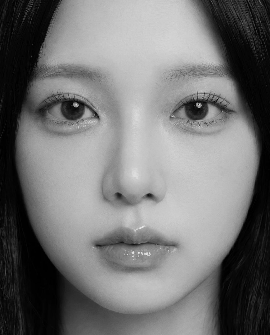 Close-up black and white portrait of a young East Asian woman with long dark hair, showcasing her eyes and lips with glossy makeup.