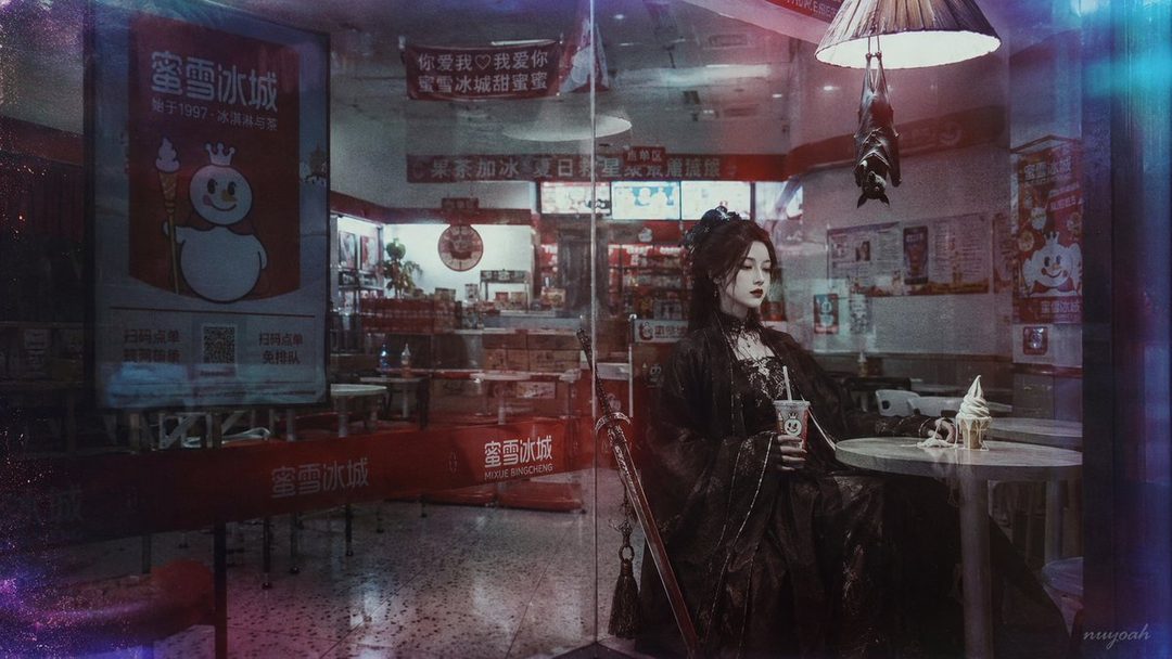A young woman in a dark, ornate dress sits at a table in a cafe, holding a drink and looking thoughtfully to the side. An ice cream cone sits on the table.