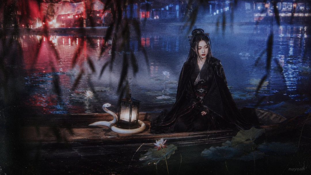 A woman in traditional Chinese attire sits in a boat at night, with a lantern and a snake beside her, on a lake with lotus flowers.