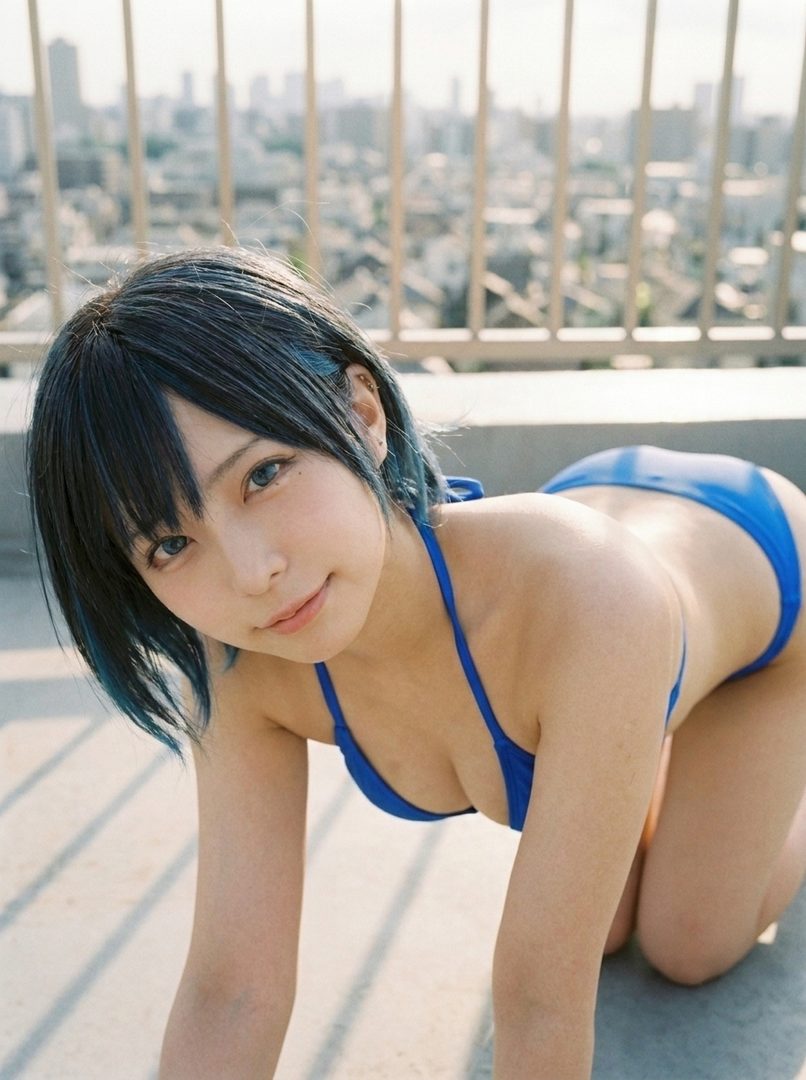A young woman with short black and blue hair wearing a blue bikini poses on a rooftop with a city skyline in the background.