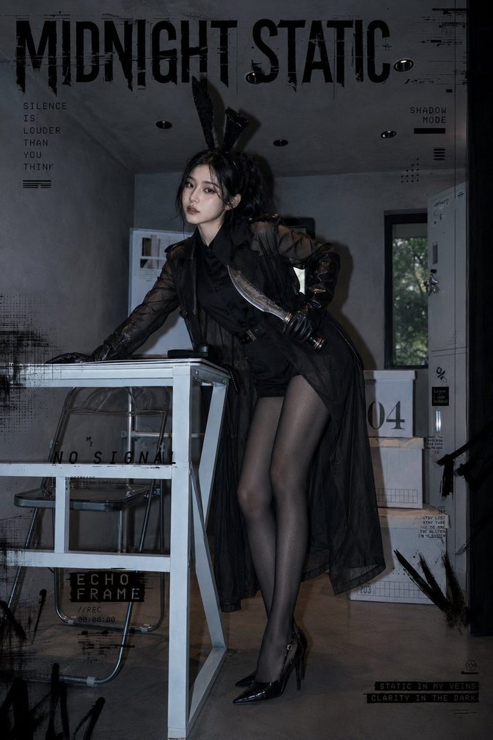 A woman with black bunny ears and a black sheer trench coat holds a knife in a dark, industrial-style room with text overlays.