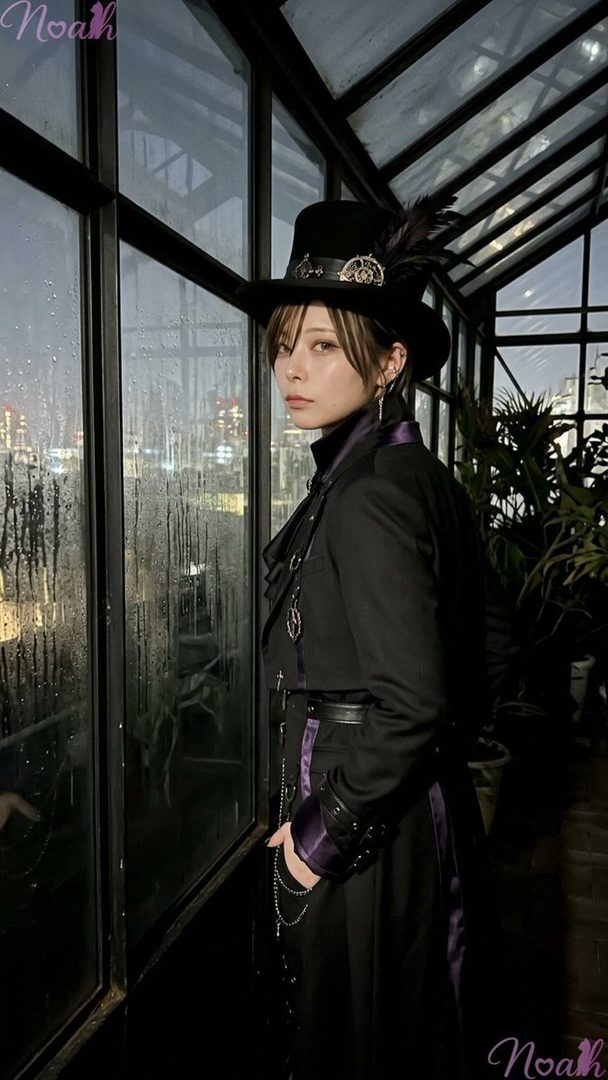 A person in a gothic-style black coat and top hat with feathers stands by a rainy window in a greenhouse at night.
