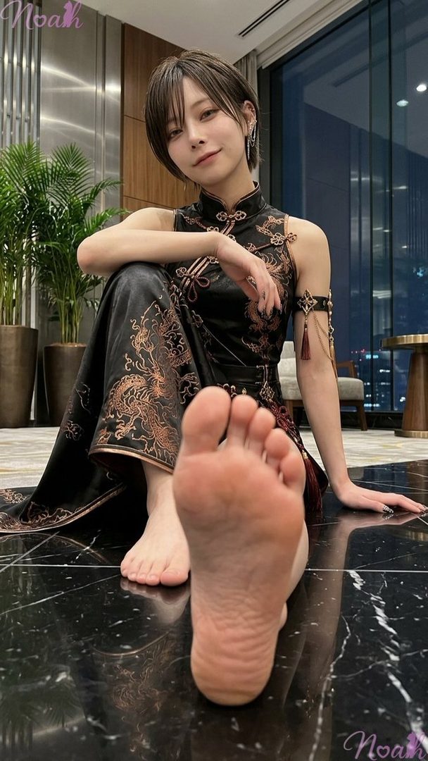 A woman with short dark hair wearing a black cheongsam with dragon embroidery sits on a dark marble floor, with one bare foot prominently in the foreground.