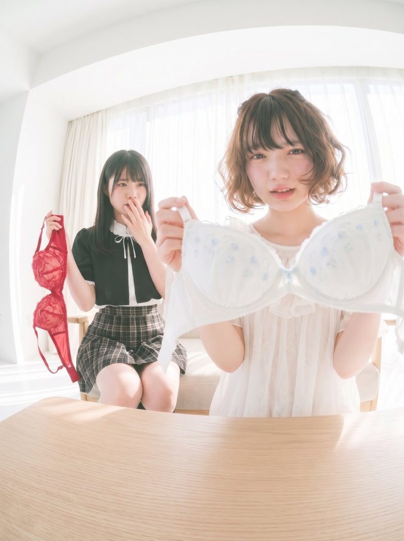 Two young women in casual indoor attire, one holding a red bra and the other a white bra, with a bright, airy background.