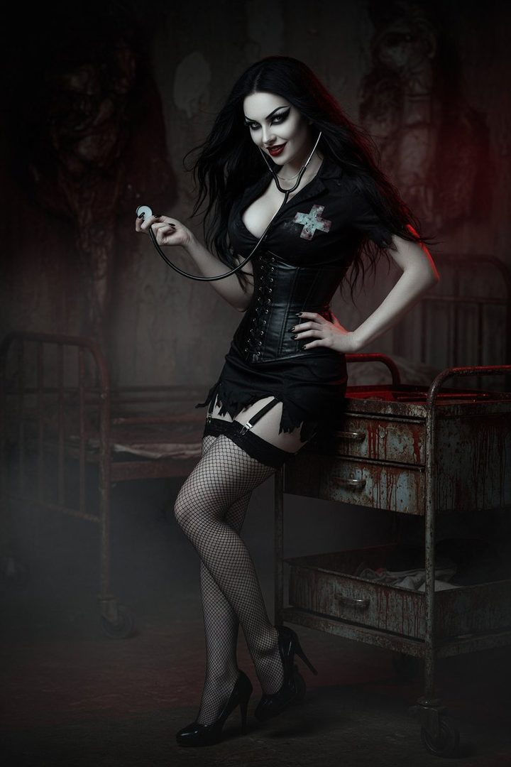 A gothic nurse with long black hair and dramatic makeup, wearing a provocative black uniform, fishnet stockings, and holding a stethoscope, poses seductively in a dark, eerie setting.