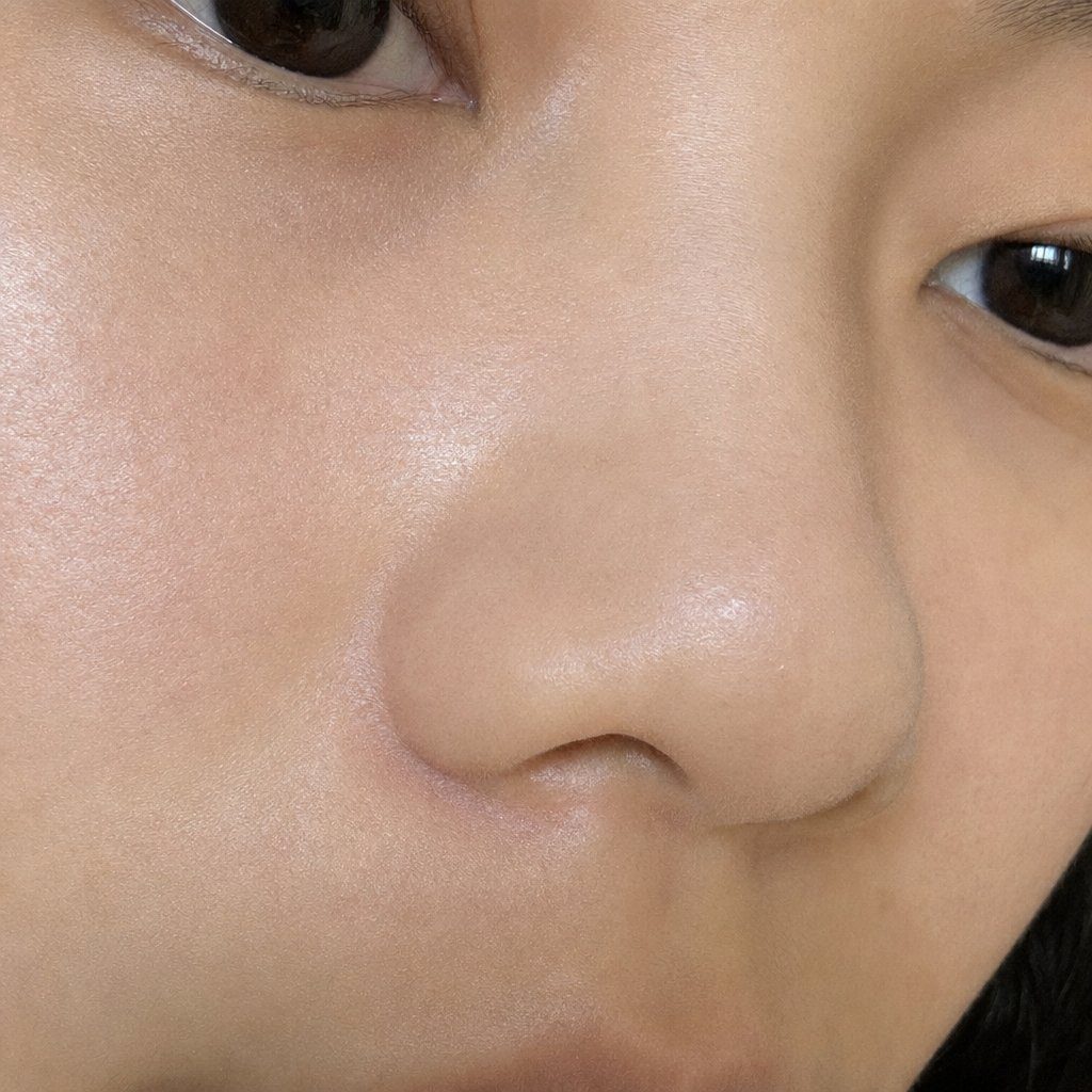 Close-up portrait of a young East Asian woman's face, focusing on her eyes and nose, with smooth skin and dark hair.