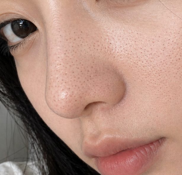 Close-up of a young East Asian woman's face, focusing on her nose and lips, with visible pores.