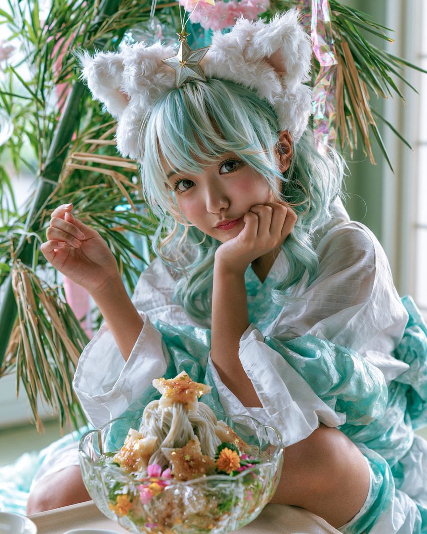 A cute AI idol with light blue hair and cat ears, wearing a white and teal yukata, poses with a bowl of somen noodles decorated with star-shaped toppings and flowers.