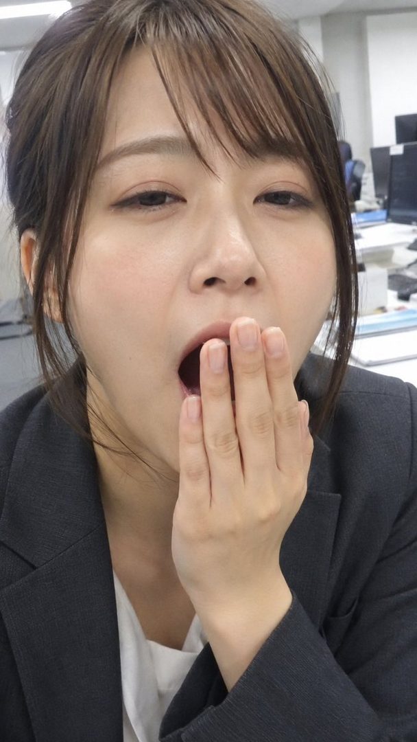A photorealistic portrait of a woman in an office setting, yawning with her hand covering her mouth.