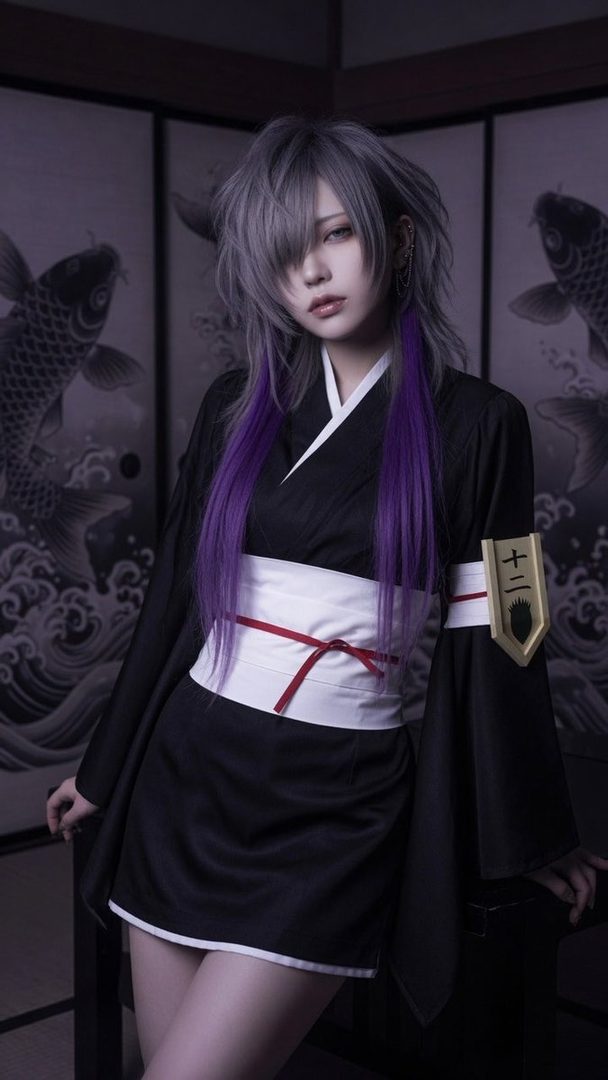 A person with long grey and purple hair, dressed in a black kimono with a white obi, poses indoors with traditional Japanese screens in the background.