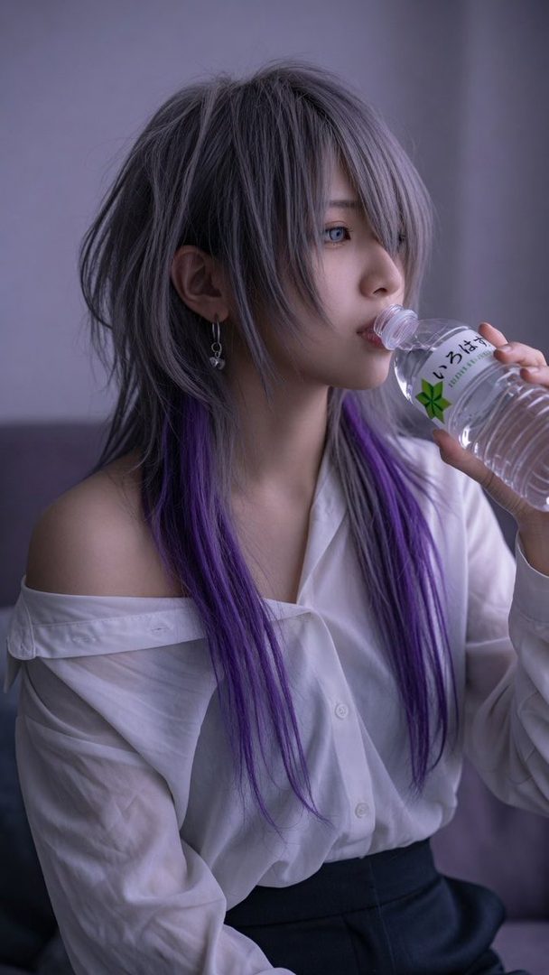 A person with silver and purple hair drinks water from a bottle, wearing a white off-shoulder shirt.