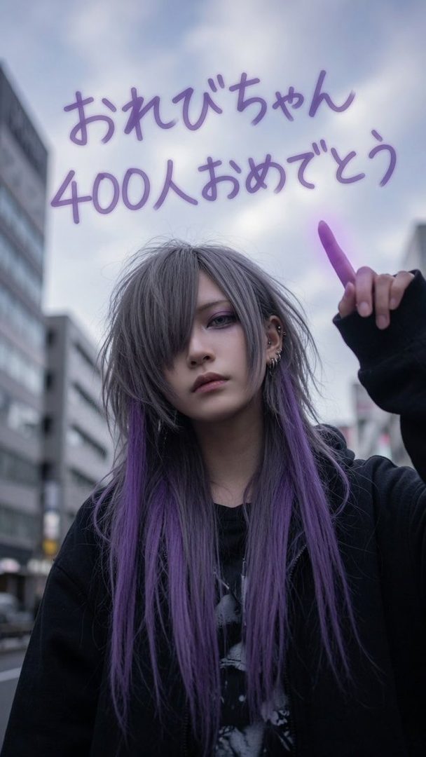 A person with long grey and purple hair, wearing a black hoodie, stands on a city street with buildings in the background and Japanese text overlaid.