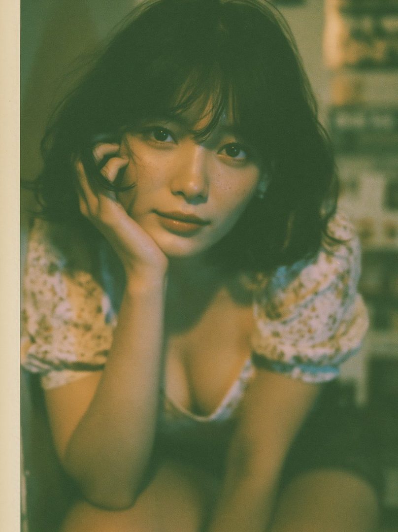 A dreamy portrait of an East Asian woman with short black hair and bangs, wearing a floral blouse, resting her chin on her hand.