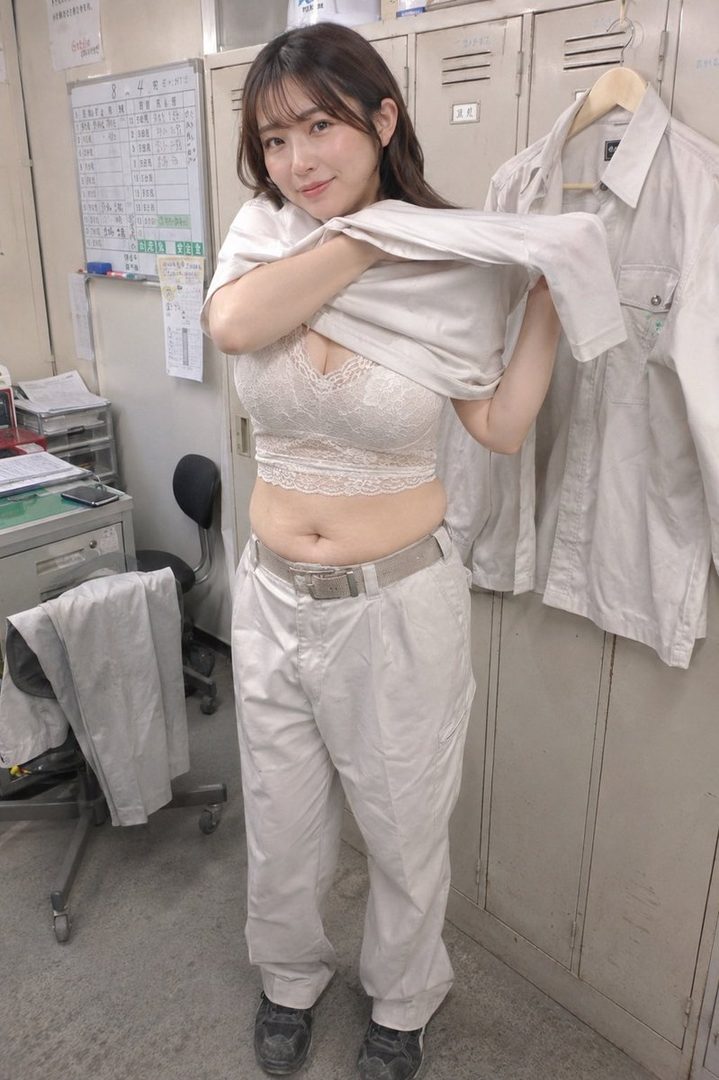 A woman in a white lace bralette and work pants is seen in an indoor setting, pulling up a white shirt.