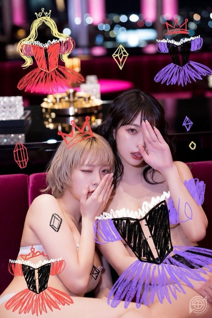 Two women with drawn-on outfits and crowns pose playfully indoors.