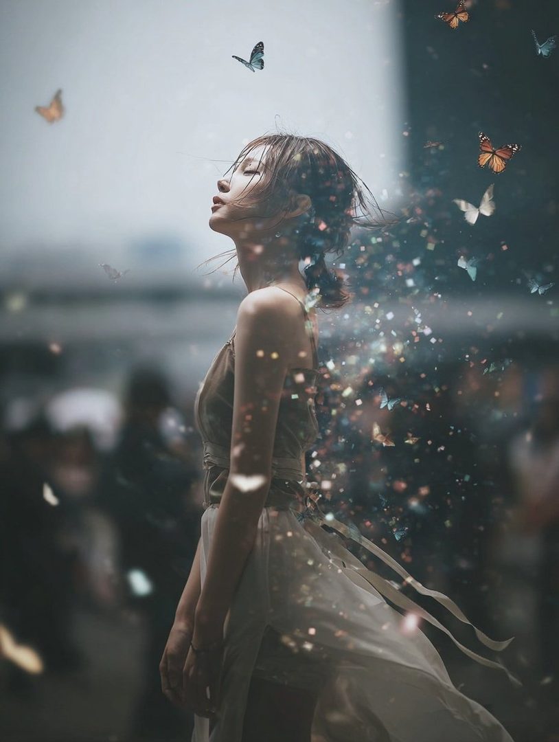 A dreamy portrait of a woman with her eyes closed, surrounded by sparkling particles and butterflies.