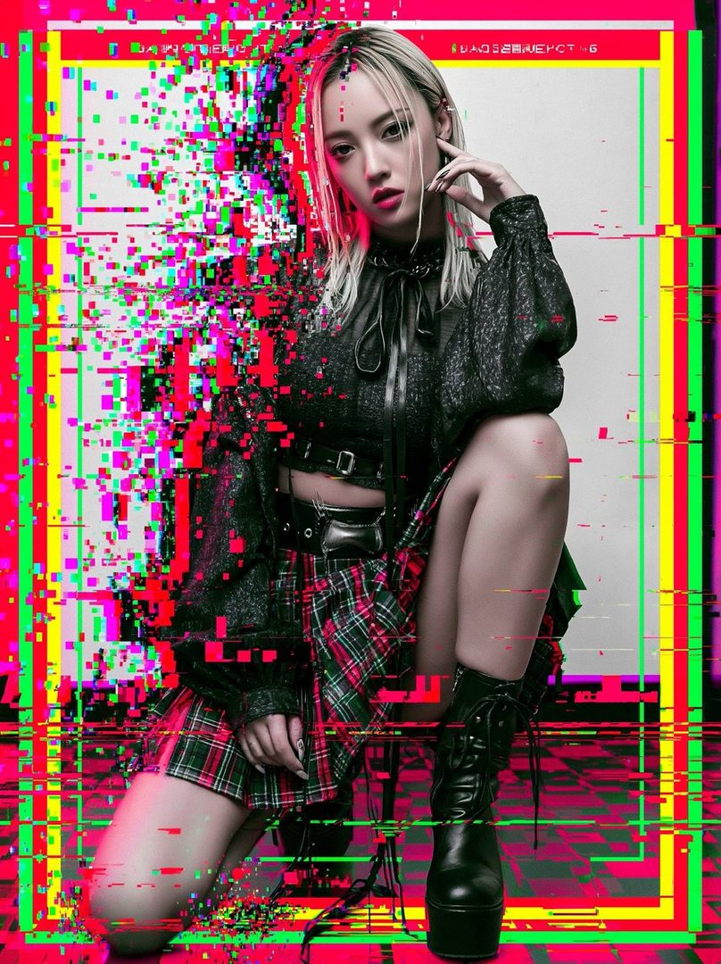 A woman with blonde hair and a plaid skirt poses in a studio with a glitch art effect.