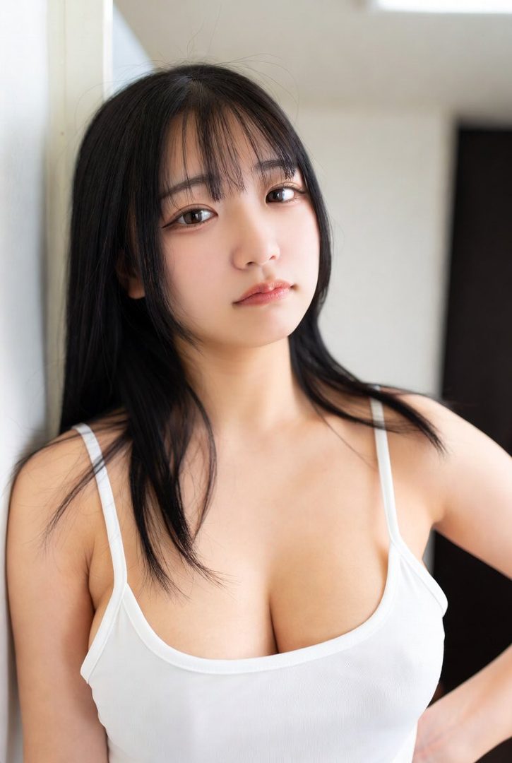 A young East Asian woman with long black hair and bangs wears a white camisole, looking directly at the camera.