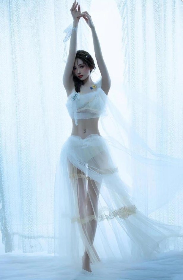 A woman in a sheer white two-piece outfit with her arms raised, standing in a dreamy indoor setting.