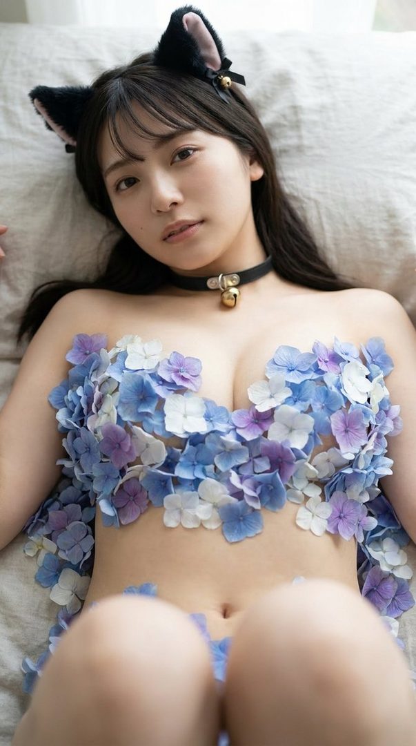 A woman with cat ears and a bell collar lies down, covered in blue and purple flowers.