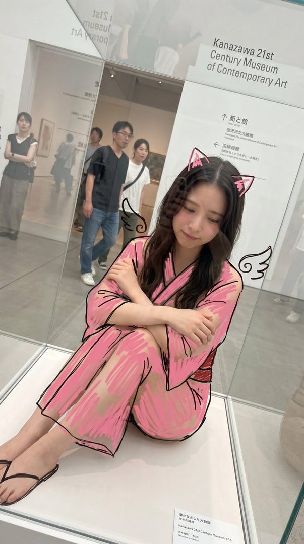 A young woman with long dark wavy hair is sitting on a display case in an art museum, with a cartoon-style pink kimono and cat ears drawn over her.