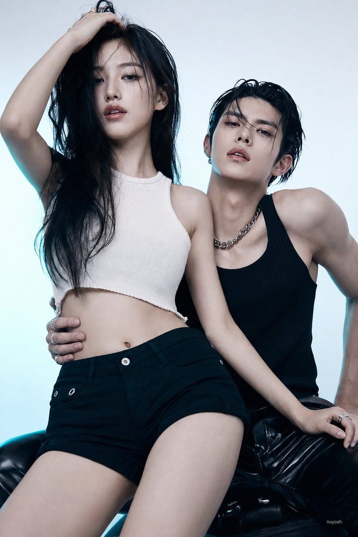 A photorealistic image of an East Asian couple posing intimately in a studio, with the woman wearing a white crop top and black shorts, and the man in a black tank top.