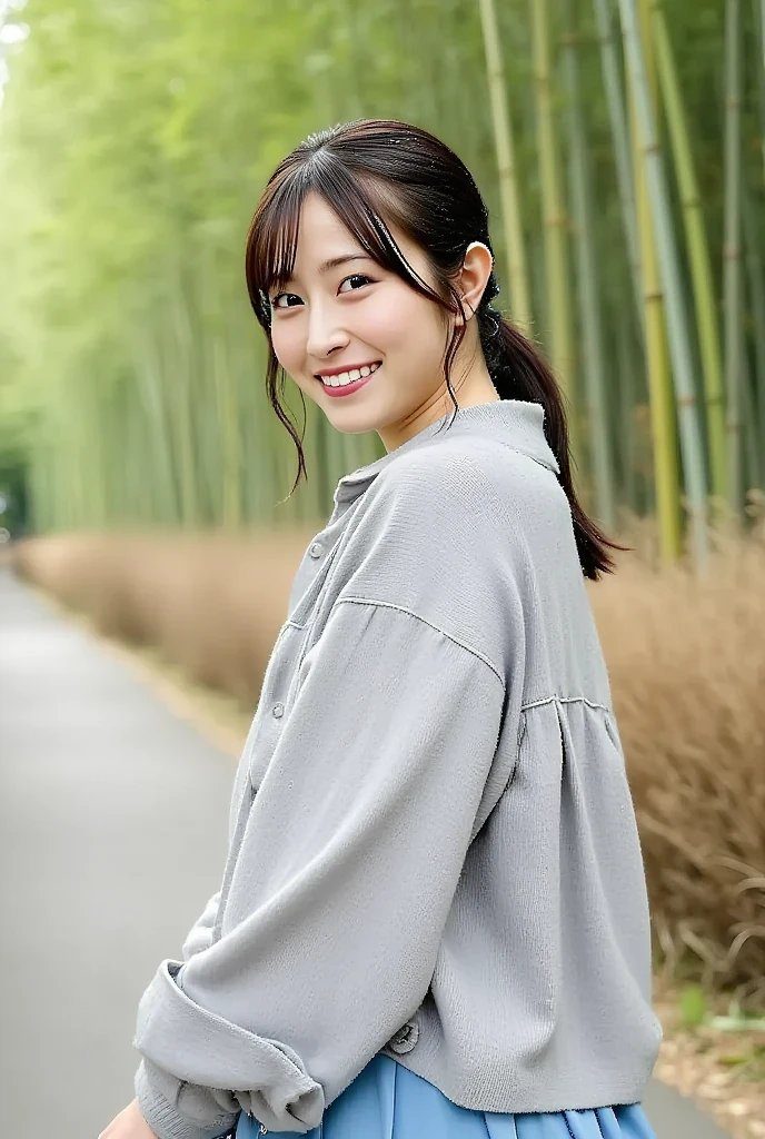 A young woman with brown hair tied in a ponytail and bangs smiles while looking over her shoulder in a bamboo forest.