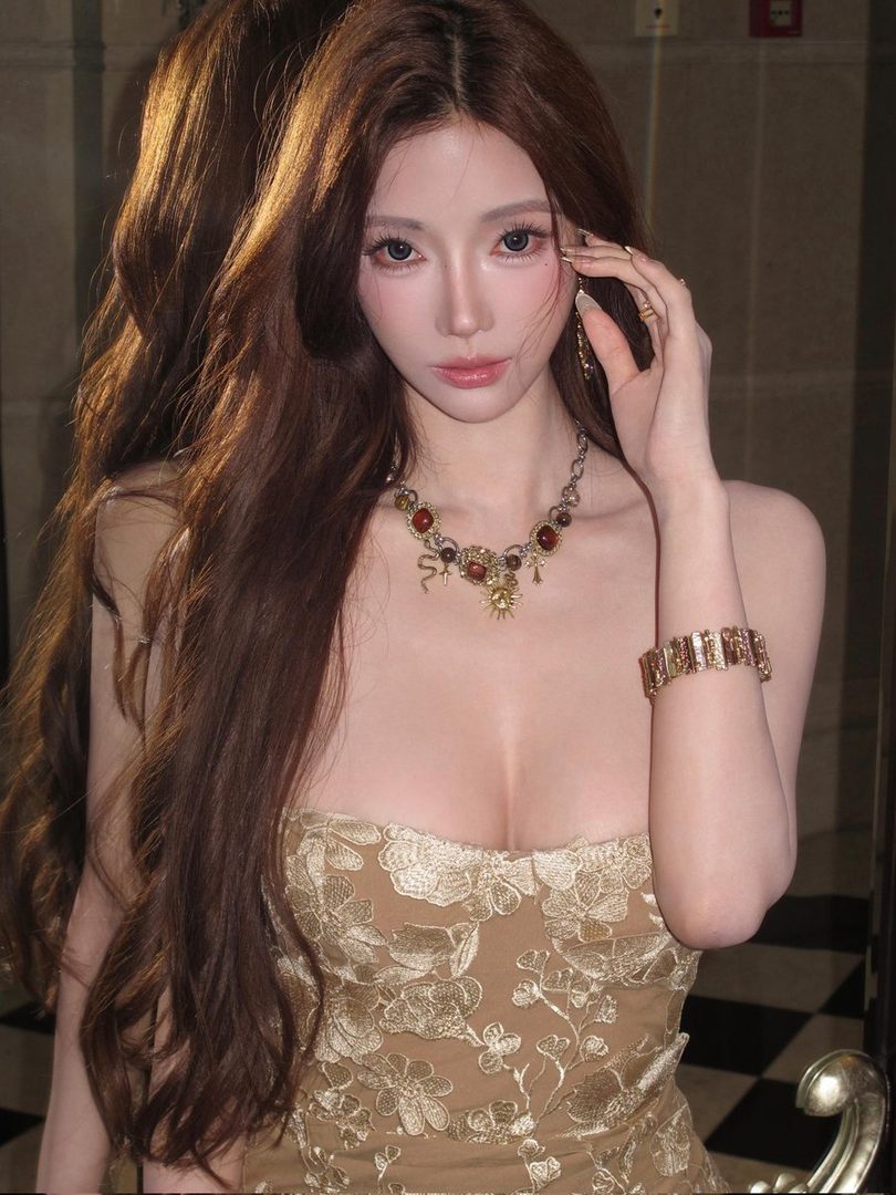 A photorealistic portrait of a woman with long brown hair wearing a gold strapless dress and ornate jewelry.
