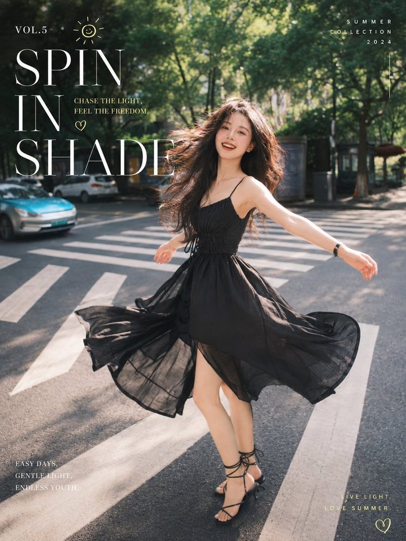 A young woman with long black hair in a black dress smiles and spins on a crosswalk on a sunny day.