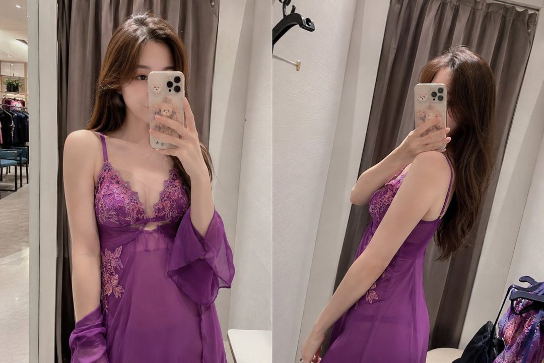 A woman in a purple nightgown takes a mirror selfie, showing off the lace details and sheer fabric.