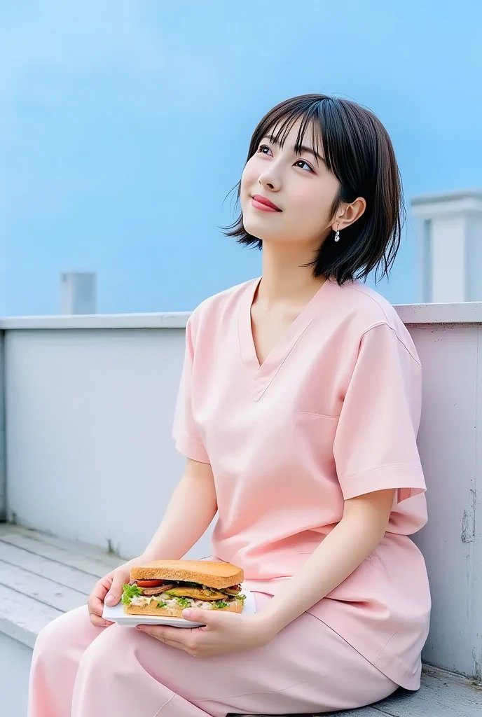 A young woman with short black hair and bangs, wearing a pink casual outfit, sits outdoors holding a sandwich and looking up at the sky.