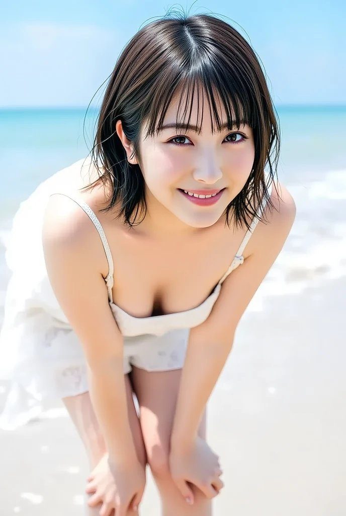 A young woman with short brown hair smiles at the camera while bending forward on a sunny beach.