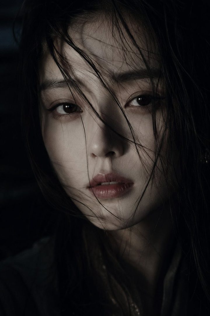 Cinematic close-up portrait of an East Asian woman with long, dark, slightly messy hair falling across her face, exuding a cool and elegant beauty.